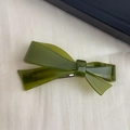 Close-up of olive green acetate bow hair clip with gold France Handmade lettering - Green