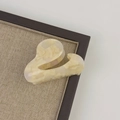Detail view of small cream acetate hair claw clip with marble texture and gold lettering - Milk Coffee