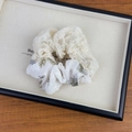 Détail du chouchou en dentelle florale avec motif de feuilles vert-gris sur plateau - Standard / Grand Chouchou à Fleur Verte
