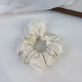 Dettaglio dell'elastico in pizzo con trama satinata e fiocco con perla decorativa - Bianco Sporco