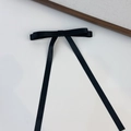 Dettaglio di un elegante fiocco per capelli in raso nero con lunghi nastri su sfondo bianco - Nero