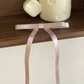 Macro detail of elegant satin bow hair clip with long ribbons in soft dusty rose pink - Purple Pink