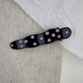 Detail of wavy metal hair clip featuring pink polka dots on a black finish base - Wave Style