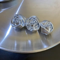 Detailansicht der silbernen Rosen-Haarklammer mit drei Blumen auf einem Metalltablett - Federclips
