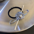 Detailansicht der silbernen Metallrose und Schleife auf einem schwarzen Haargummi - Schleife Blume Haargummi