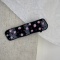 Close-up of pink polka dots on black rectangular metal hair clip with glossy finish - Cube Style