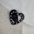Detail view of the black heart-shaped hair clip with elegant pink polka dot enamel finish - Open Heart Style