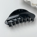 Detail of glossy black acetate hair claw clip showing a smooth finish and curved design - L Black