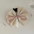 Dettaglio di un elastico in pizzo crema con fiocco rosa e ricami floreali eleganti - Rosa