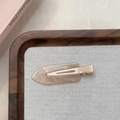 Detailopname van crème marmeren hars haarklem met gouden glitters en metalen basis - Lichtroze