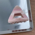 Détail d'une pince à cheveux triangulaire en acétate rose avec logo doré fait main - Rose