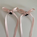 Detailansicht der rosa Satin-Schleifen-Haarklammern mit kleinen schwarzen Greifern - Rosa