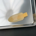 Gros plan d'une pince à cheveux en résine jaune translucide sur un plateau en métal - Jaune gelée