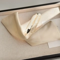 Dettaglio della trama in raso crema e dell'elegante nodo sulla clip per capelli a banana - Beige