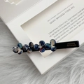 Detailed close-up of blue marble resin flower hair clip with France Handmade engraving - Navy Blue