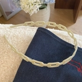 Gros plan du serre-tête en chaîne d'acétate beige sur denim et tissu blanc doux - Vert clair