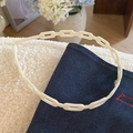 Primer plano detallado de la diadema de eslabones crema sobre telas blancas y denim - Blanco Leche