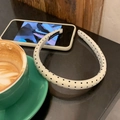 Nahaufnahme eines handgefertigten beigen Haarreifs mit schwarzen Punkten auf einem Kaffeetisch - Schmaler Stil / Beige