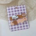 Detalle de pinzas para el pelo de perro y oso sobre tarjeta de cuadros morados - Bichon Blanco