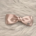 Detail der rosa Satin-Schleifen-Haarspange mit Lagenstoff und silberner Plakette - Rosa