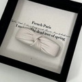 Detail of cream PU leather knotted hair clip with elegant textured finish and bow design - Off-white
