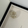 Macro view of a mini round marble acetate hair claw with cream and beige patterns - Beige