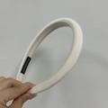 Detail eines weichen cremeweißen Samtstirnbands mit Handmade-Etikett und Polsterung - Cremeweiß