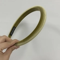 Detail der handgefertigten Samt-Stirnband-Textur und des inneren Stoffetiketts - Grün