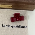 Close-up of a burgundy acetate bow hair claw clip on a rustic textured background - Burgundy