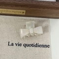 Close-up of cream-white acetate bow hair claw clip with pearlescent texture and elegant design - Mermaid Color