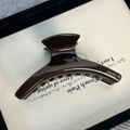 Close-up of chocolate acetate hair claw with gold Barrette La France lettering details - Crescent Moon
