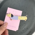 Détail d'une pince à cheveux teckel jaune avec carreaux violets sur carte rose - Chien à Carreaux Bleu