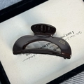 Close-up of a chocolate brown acetate hair claw with gold Barrette La France lettering - Semicircle Style