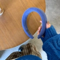 Detailed macro of thick blue plush velvet headband featuring a woven handmade label - Blue