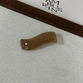 Détail de la pince à cheveux ondulée en acétate marron avec lettrage doré - Café au Lait