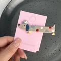 Vue détaillée d'une pince à cheveux teckel avec des pois colorés sur une carte - Chien à Pois Coloré