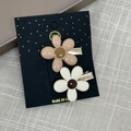Vue détaillée de barrettes à fleurs en résine marron lait et blanc crème sur carte - Fleurs Café Au Lait (Paire)
