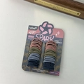 Macro detail of multi-colored baby size hair elastics on a paper display card - Morandi Colors