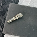 Nahaufnahme geometrischer Kristalle auf einer luxuriösen silberfarbenen Haarspange - Wassertropfen-Stil / Grau