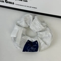 Dettaglio dell'elastico a righe grigie con etichetta di orso e decorazione a nastro - Etichetta Blu Orso