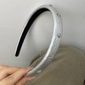 Détail d'un serre-tête en cuir argenté avec étoiles métalliques et strass étincelants - Argenté