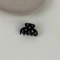 Close-up of black acetate hair claw clip with colorful rhinestones and gold lettering - Black