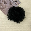 Close-up of black fluffy plush hair scrunchie with soft curly faux fur texture on knit background - Black