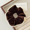 Dettaglio dell'elastico in velluto marrone scuro con perle bianche e ciondolo d'oro - Marrone