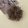 Vue détaillée d'un chouchou en peluche marron doux sur fond texturé de couleur beige - Marron