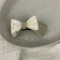 Detailed macro shot of the acetate marble pattern and smooth spring clip texture - 3D Bow-Milky Coffee