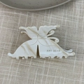 Detail view of cream marble butterfly hair claw with sawtooth grip and brand logo - Off White