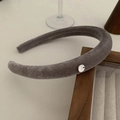 Detailed close-up of grey velvet padded headband with a small silver metal brand logo - Gray