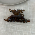Detailed view of butterfly claw clip with tortoiseshell pattern on linen fabric - Blue Brown Gradient