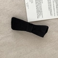 Eleganter schwarzer Samt-Haarclip mit Vintage-Schleife auf beigefarbenem Stoffhintergrund - Schwarz